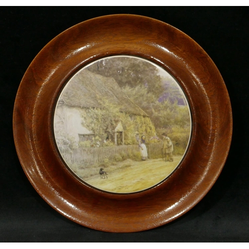 77 - A circular china teapot stand mounted in mahogany frame, depicting figures outside cottage, 24.5cm d... 