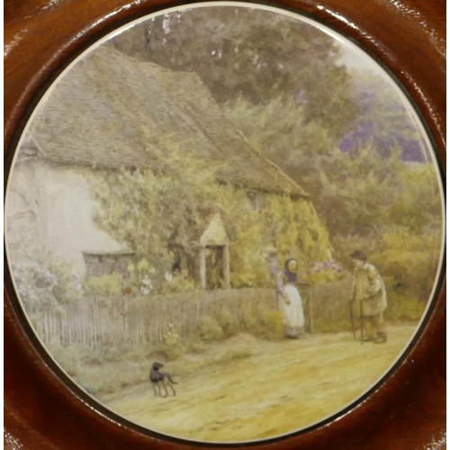 77 - A circular china teapot stand mounted in mahogany frame, depicting figures outside cottage, 24.5cm d... 