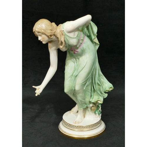 91 - A Meissen large figure of a lady stooping on round base (finger on right hand a/f), 35cm high.