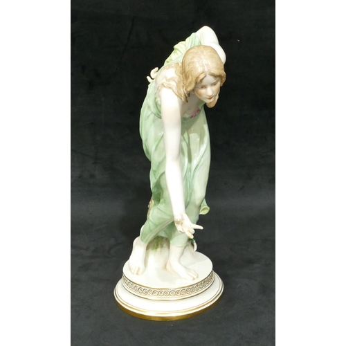 91 - A Meissen large figure of a lady stooping on round base (finger on right hand a/f), 35cm high.