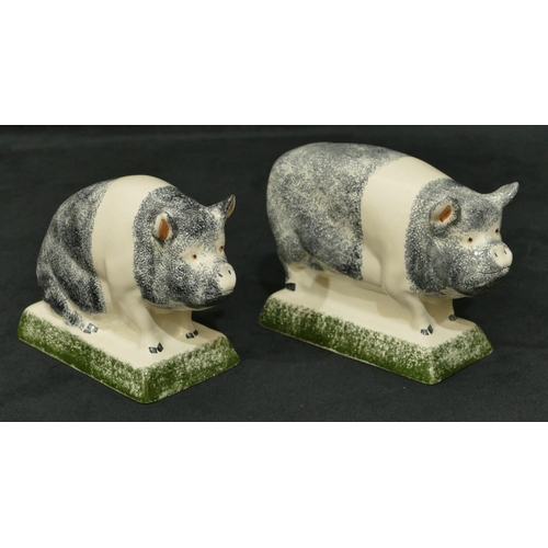 92 - A pair of Rye Pottery figures of pigs on rectangular shaped bases, 16cm long, 11cm high.