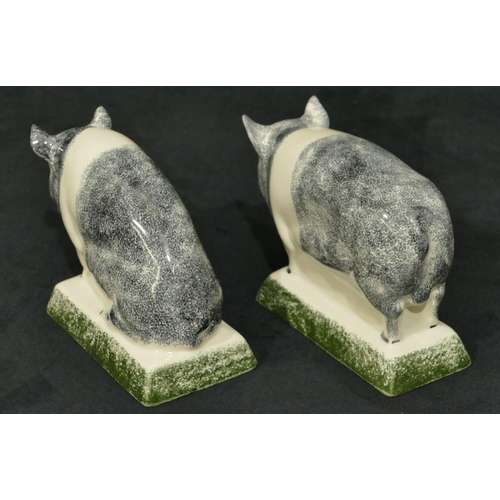 92 - A pair of Rye Pottery figures of pigs on rectangular shaped bases, 16cm long, 11cm high.