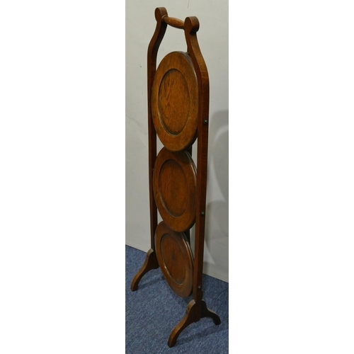 631 - A 1920's oak 3-tier folding cake stand on splayed feet, 91cm high.