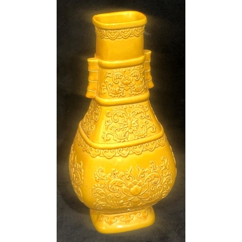 61 - An Oriental rectangular bulbous thin necked 2- handled vase on yellow ground with raised floral and ... 