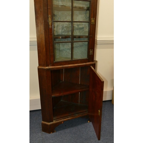 639 - A George III walnut freestanding corner cupboard with glass panel door enclosing shaped shelves, fur... 