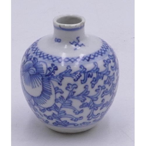 97 - An Oriental small round bulbous thin necked vase on blue and white ground with floral and leaf decor... 