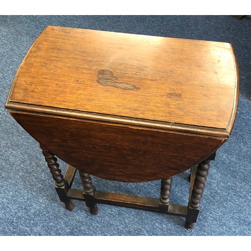 6001 - A 1920's oak oval small gate leg table on barley twist legs, 71.5cm high, 92.5cm wide, 61cm deep.