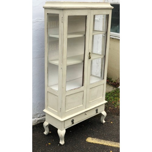 6062 - A painted display cabinet, 2 panel doors enclosing shelves, 1 drawer below on cabriole legs, 84cm wi... 