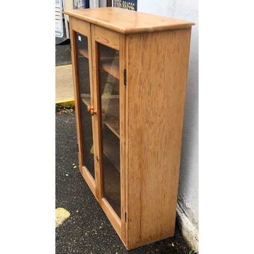 6063 - A pine low display cabinet, 2 glass panel doors, 82cm wide, 30cm deep, 106cm high.