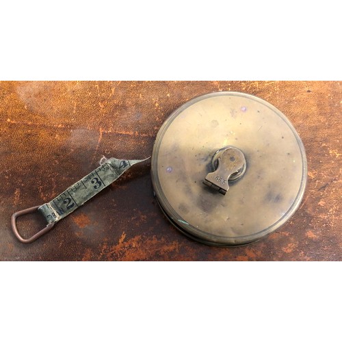 6044 - A modern brown leather oval tray with red interior, labelled 