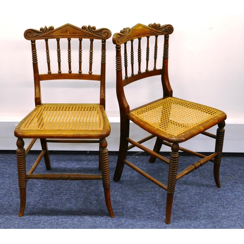 1162 - A pair of walnut single chairs with spindle backs and cane seats on splayed legs (2)