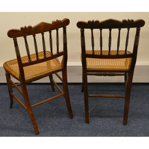 1162 - A pair of walnut single chairs with spindle backs and cane seats on splayed legs (2)