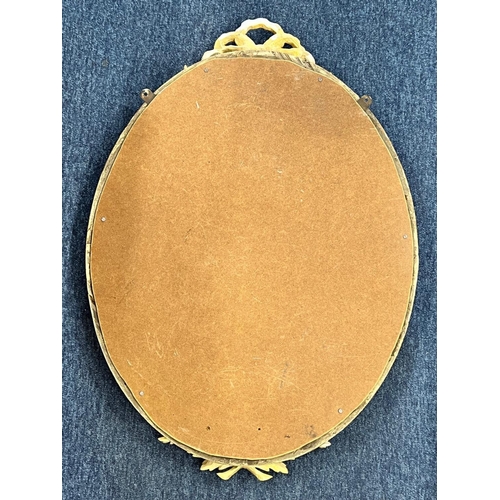 1175 - A 19th Century oval gilt hanging wall mirror having raised ribbon motif 82cm high  57cm wide