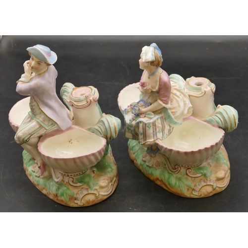 15 - A pair of Continental china salts with figure motifs seated upon oval shells, 17cm wide, 17.5cm high