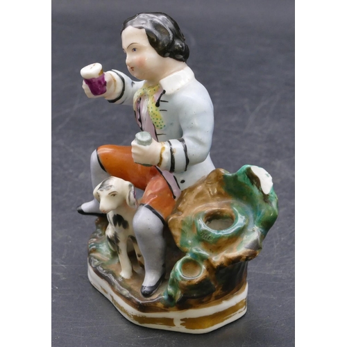 165 - A 19th Century china pen holder in the form of a seated gentleman with a dog at his feet, 11.5cm hig... 