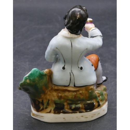 165 - A 19th Century china pen holder in the form of a seated gentleman with a dog at his feet, 11.5cm hig... 