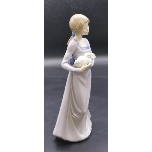 179 - A Nao figure of a young standing lady holding a rabbit, 25cm high.