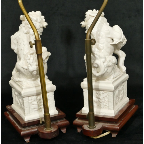 186 - A pair of Oriental Blanc de Chine figures of Dogs of Fo on plinths, 28cm high, both mounted on woode... 