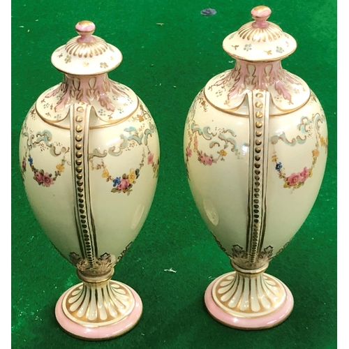 194 - A Pair Royal Crown Derby round bulbous thin necked 2 handled lidded vases on cream ground with flora... 