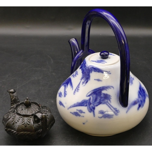 24 - A miniature black round bulbous shaped teapot with raised leaf and scroll decoration, 6.5cm high (sl... 