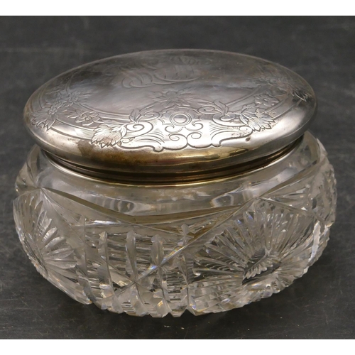 245 - A cut glass round bulbous dressing table bottle with sterling silver lid engraved with floral, leaf ... 