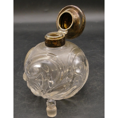 248 - A heavy cut glass round bulbous shaped scent bottle with London silver neck and hinged lid with embo... 