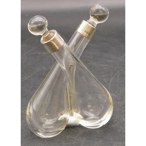 251 - A plain glass double-ended vinegar bottle with stoppers and Birmingham silver necks, 13.5cm high