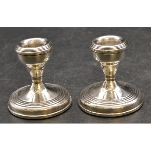 252 - A pair of modern Birmingham silver dwarf candlesticks on round sweeping bases, 7cm high