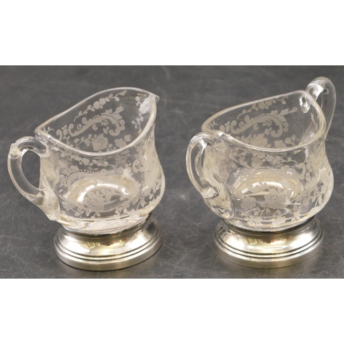 255 - A round bulbous 2-handled glass sugar bowl and matching cream jug with etched, floral, leaf and scro... 