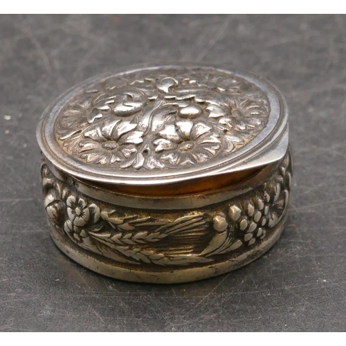 277 - A modern 925 silver round pill box with hinged lid and embossed floral and scroll decoration, 3.5cm ... 