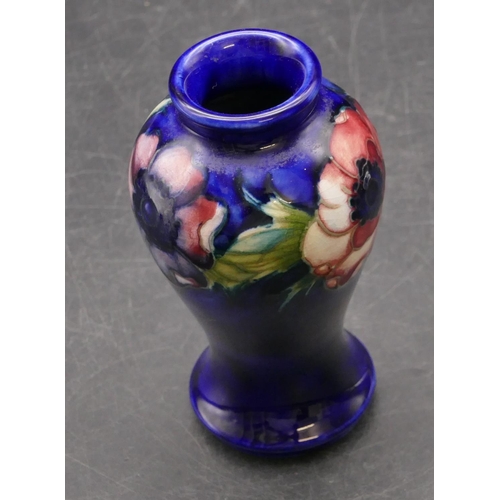 32 - A Moorcroft small round bulbous thin necked vase on blue ground with multi-coloured floral and leaf ... 