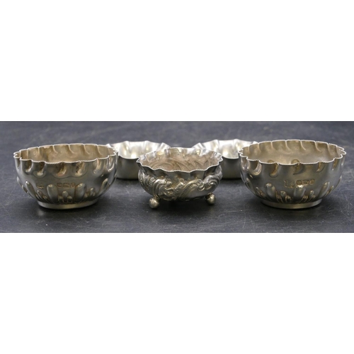 335 - A pair of Sheffield silver round scallop shaped salts with part embossed decoration and crinkled rim... 