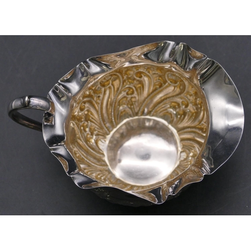 356 - A Sheffield silver round bulbous shaped cream jug with crinkled rim, embossed scroll and leaf decora... 