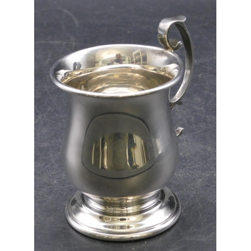 360 - A modern London silver round bulbous shaped christening mug with scroll handle on sweeping foot, 3.2... 