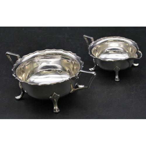 365 - A Sheffield silver round 2-handled scallop shaped sugar bowl and matching cream jug on splayed feet,... 