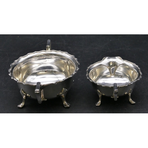 365 - A Sheffield silver round 2-handled scallop shaped sugar bowl and matching cream jug on splayed feet,... 