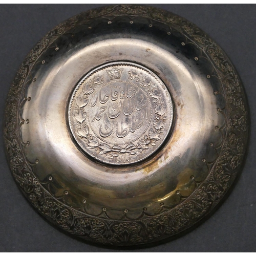 381 - A Continental silver coloured metal small round dish inset with Arabic coin with chased decoration, ... 