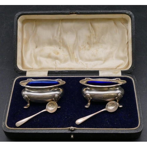 384 - A pair of Birmingham silver rectangular bulbous shaped salts with crinkled rims, blue glass liners o... 