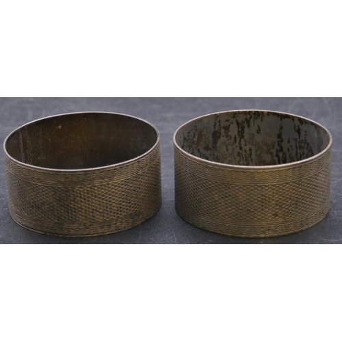 411 - A pair of Birmingham silver round napkin rings with engine turned decoration, 1oz