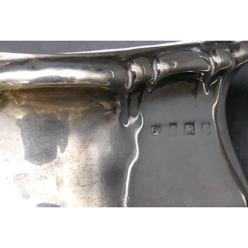 460 - A London small silver jug with embossed decoration, scroll handle and crinkled rim, 2 silver napkin ... 