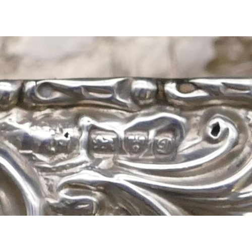 471 - An Edward VII silver rectangular shaped snuff box with hinged lid with allover embossed figure, flor... 