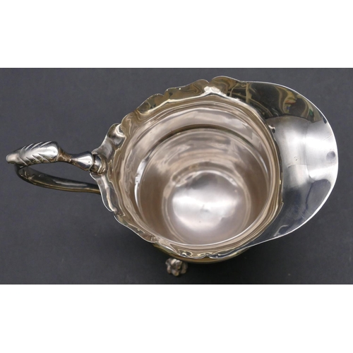 475 - An Edward VII silver milk jug with scallop shaped rim and scroll handle on 3 splayed feet, Birmingha... 