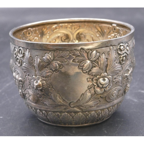 499 - A Victorian silver round sugar bowl with allover embossed floral, leaf and scroll decoration, London... 