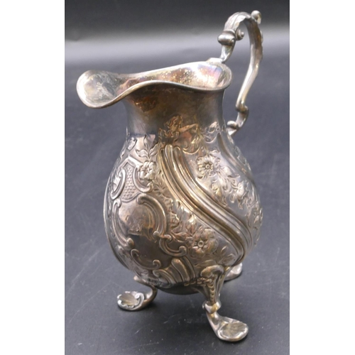 500 - A London silver round bulbous shaped milk jug with allover embossed floral, leaf and scroll decorati... 