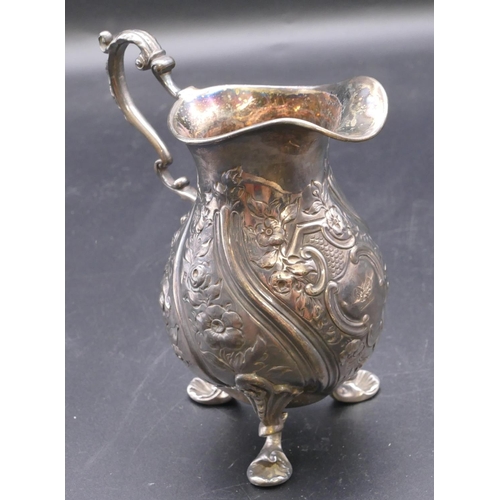 500 - A London silver round bulbous shaped milk jug with allover embossed floral, leaf and scroll decorati... 