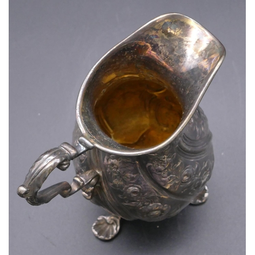 500 - A London silver round bulbous shaped milk jug with allover embossed floral, leaf and scroll decorati... 