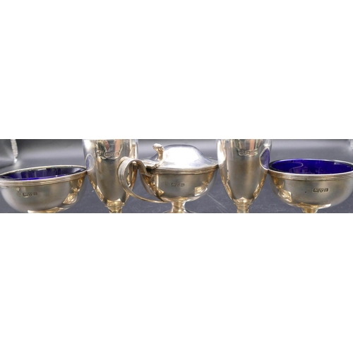 502 - A George V 5-piece condiment set, mustard pot with blue glass liner, a pair of salts with blue glass... 