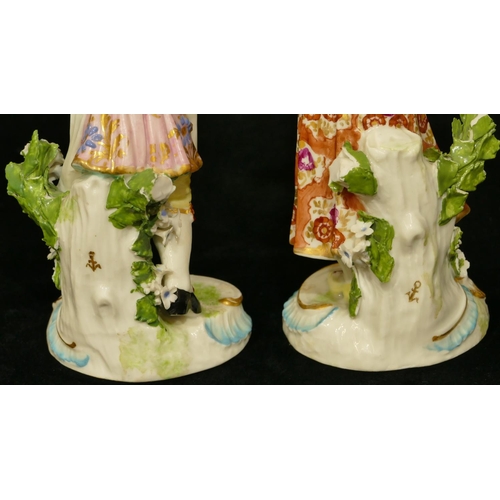 63 - A pair of Chelsea Derby porcelain figures of young gentleman and lady playing catch (both have branc... 