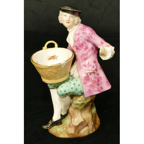 65 - A Meissen porcelain figure of a seated gentleman holding an oval basket (1 hand and thumb restored, ... 