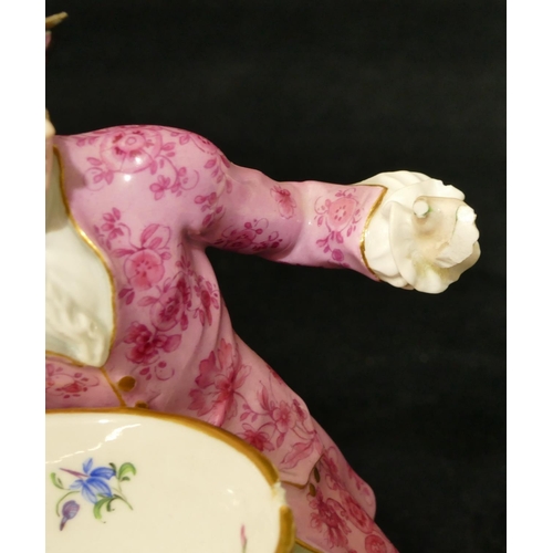 65 - A Meissen porcelain figure of a seated gentleman holding an oval basket (1 hand and thumb restored, ... 